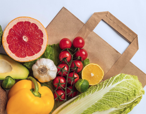 Paper Bag on White Surface With Fruits and Veggies on It